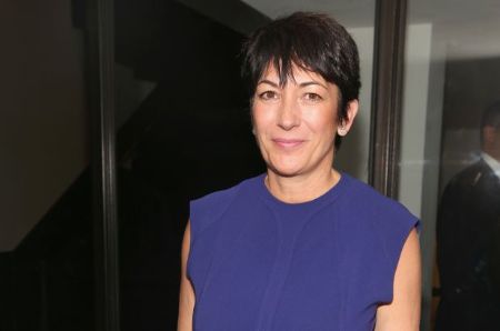 Ghislaine Maxwell in a blue dress poses for a picture.